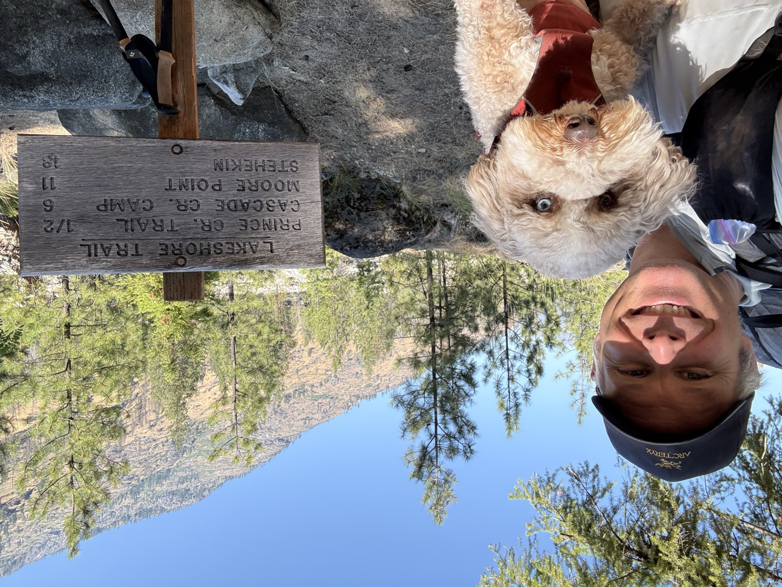 Shane and Basil at the Lakeshore Trail sign showing mileage to Cascade Creek Camp, Moore Point, and Stehekin